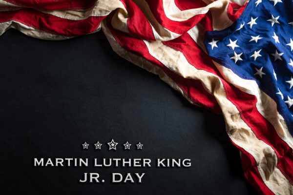 MLK Jr Day anniversary concept. American flag against black wooden background